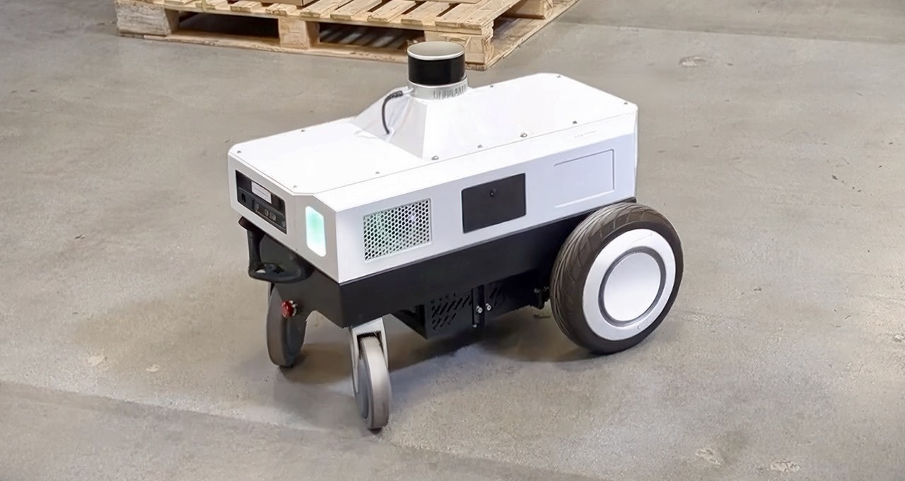 An autonomous mobile robot on a warehouse floor.